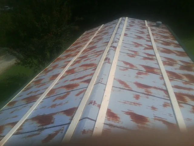 Rusted metal roof panels with new wood purlins before replacement — Storm Damage Roof Repair in New Hill by Roofing Brothers