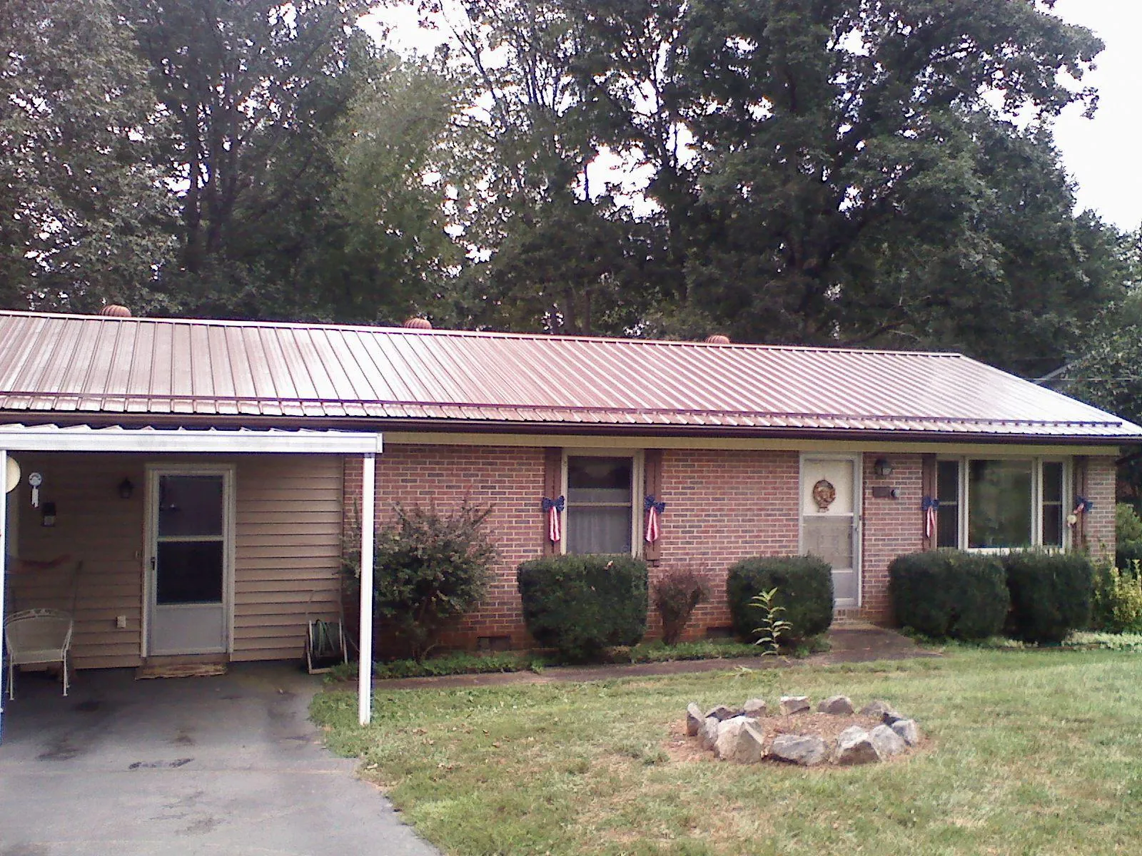 Bronze metal roof and carport on a brick ranch home — Roof Repair work by our crew in New Hill