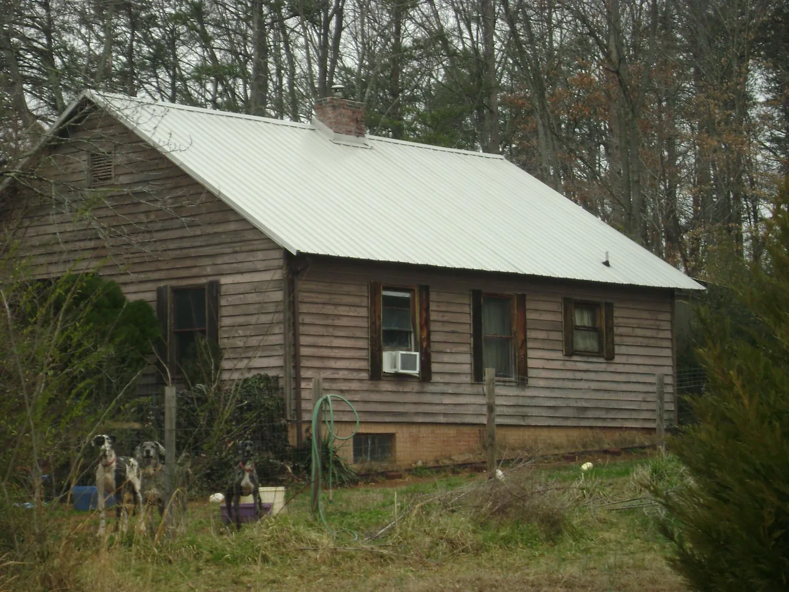 White metal roof on an old wood sided farmhouse, from a Metal Roof Installation job in New Hill